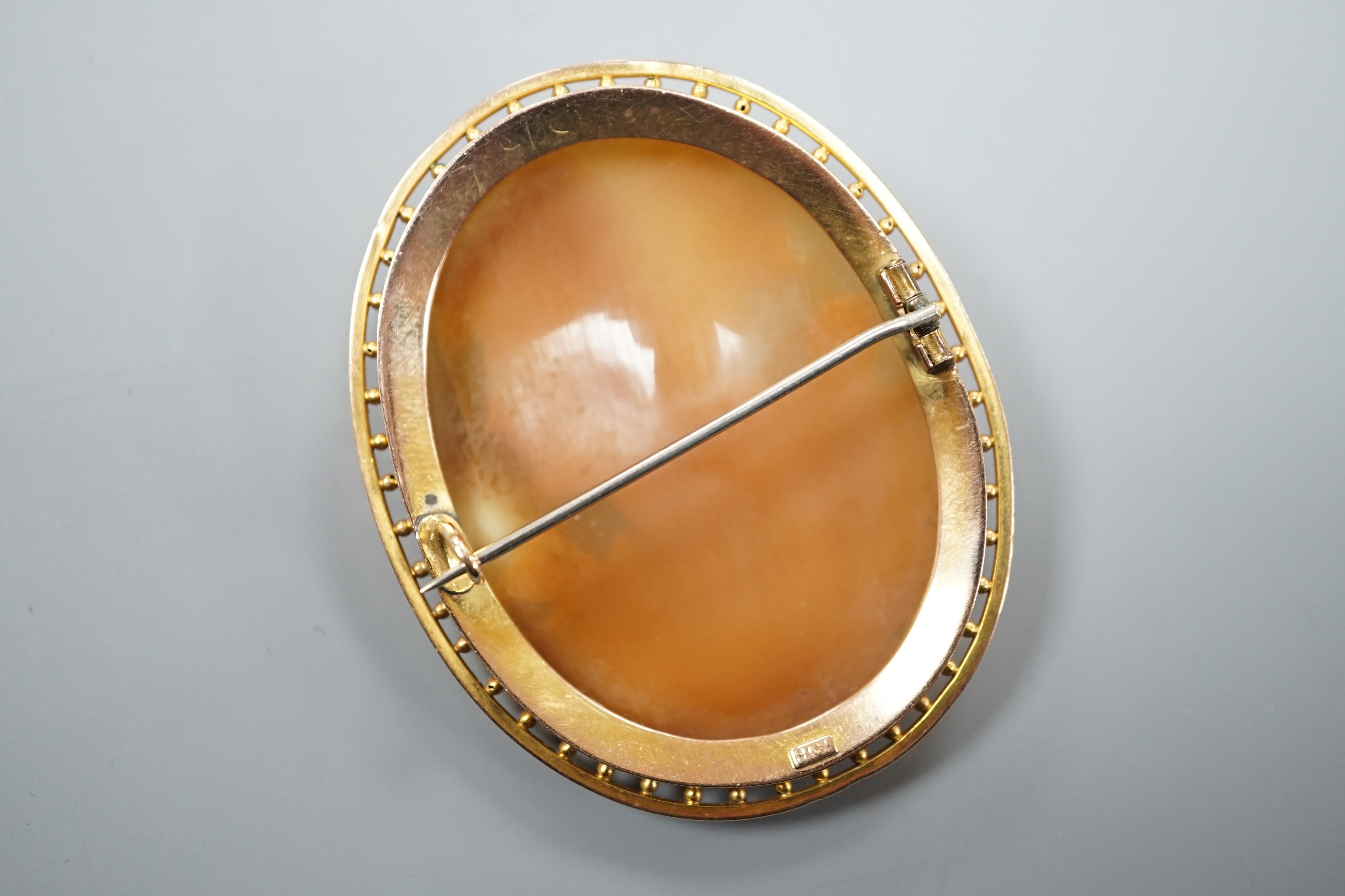 A 9ct mounted oval cameo shell brooch, carved with the bust of a lady to sinister, 5cm, gross weight 11.8 grams.